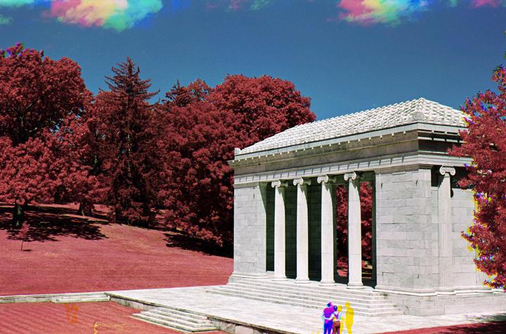 A classical building with columns stands next to a hill covered in red trees under a blue sky with colorful clouds.