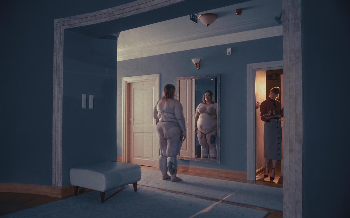 A woman stands nude in front of a mirror while another woman in a skirt and blouse holds a tray with two glasses in a doorway.