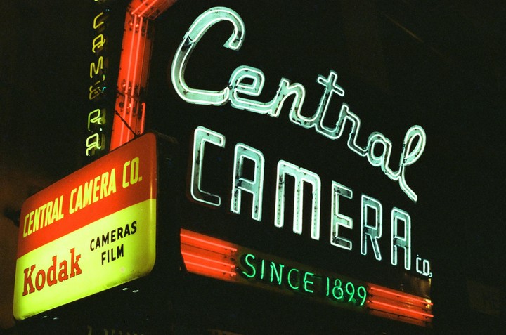 A neon sign for Central Camera Company glows in the dark.