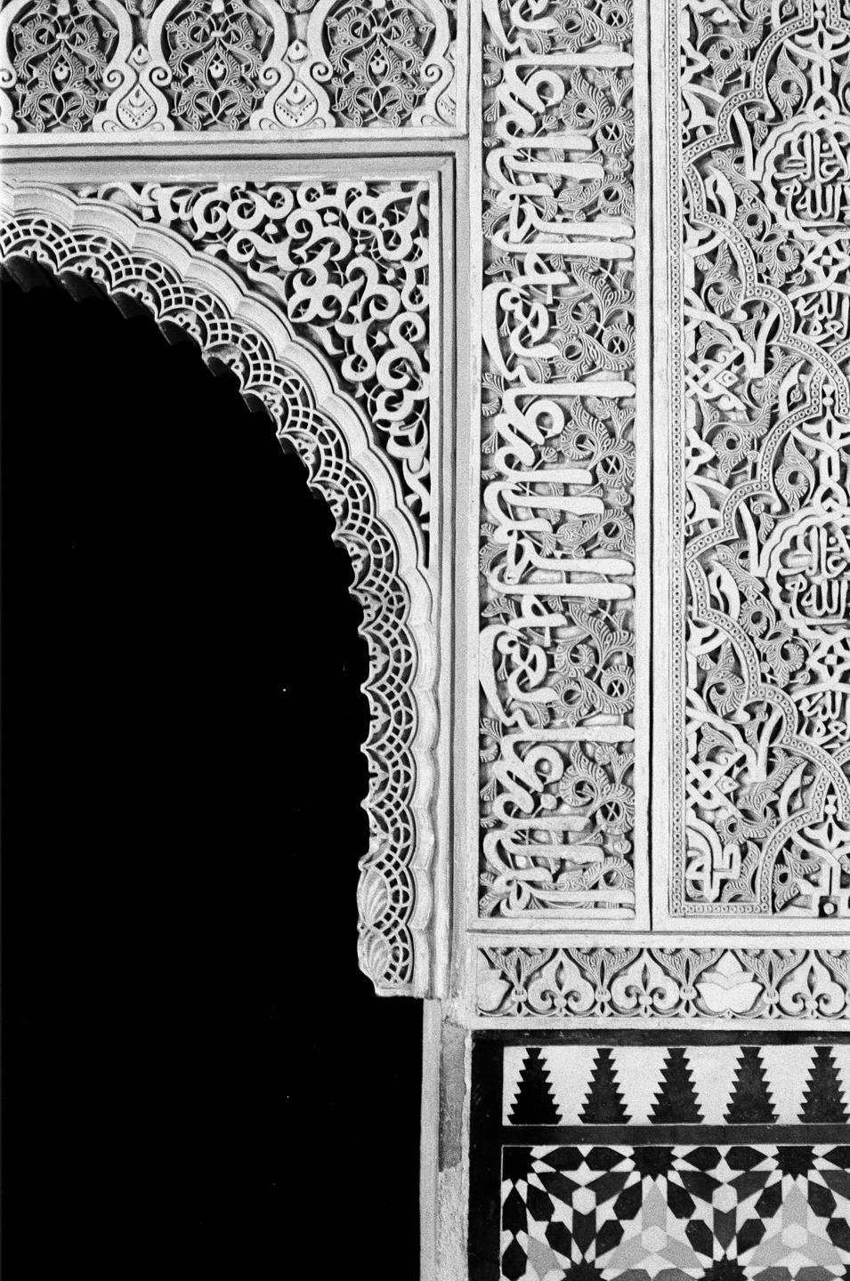 An ornate archway with intricate carvings and geometric patterns is visible.