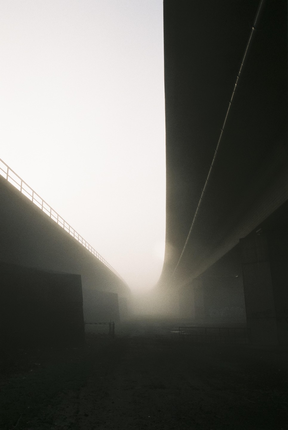Two elevated roads curve through a hazy, dark landscape.