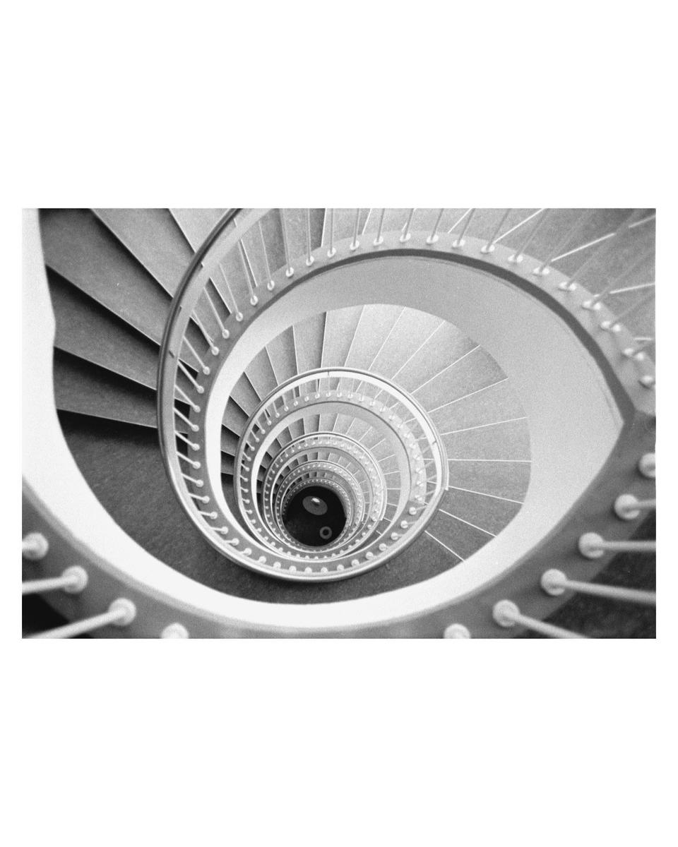 A spiral staircase is viewed from above, looking down into its center.