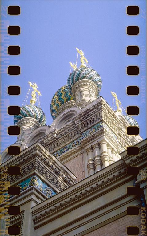 Three ornate domes with crosses on top are visible against a clear blue sky.