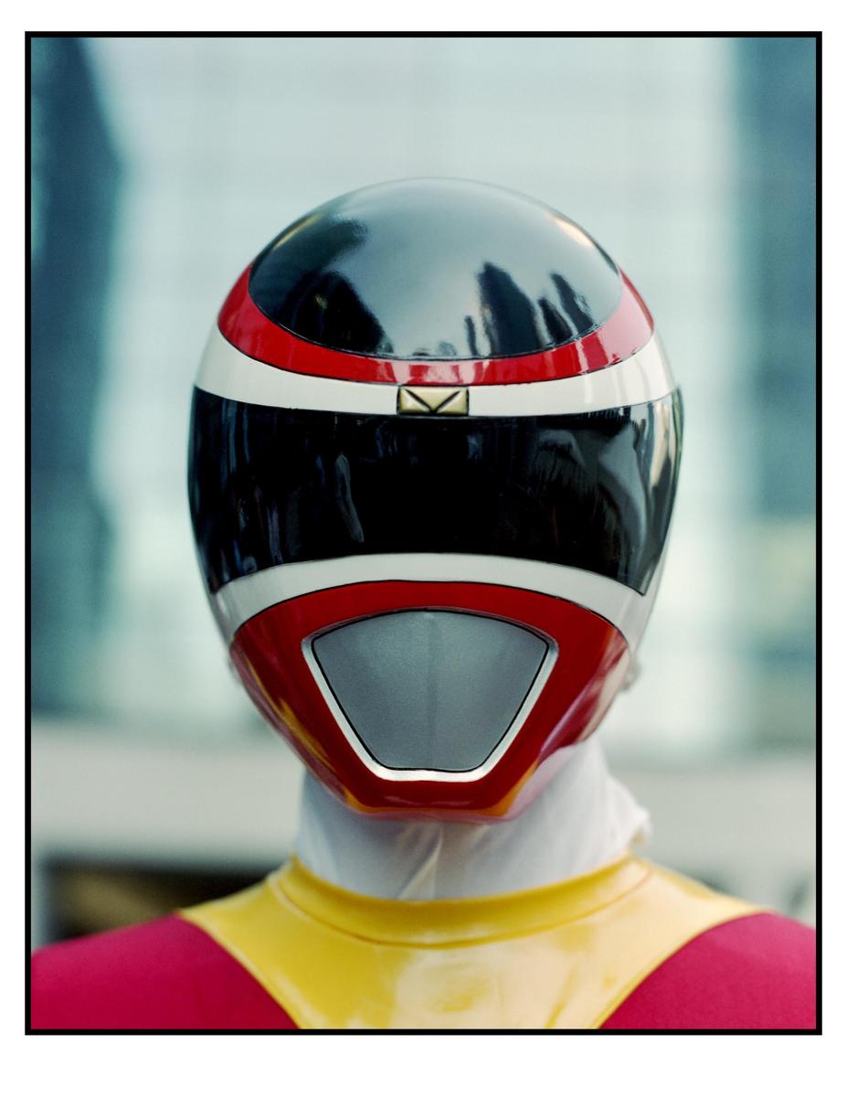A person in a red, black, and white helmet with a yellow and red suit is shown from the shoulders up.