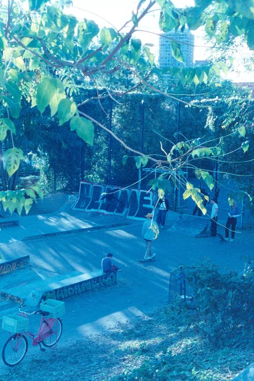 A group of people are in a skatepark with a bicycle in the foreground.