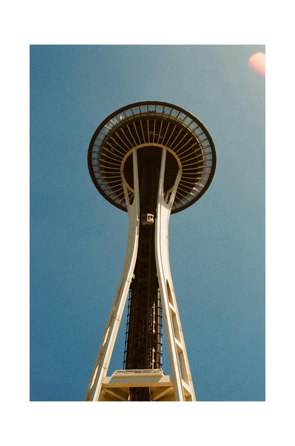 The Space Needle is visible from a low angle against a clear blue sky.