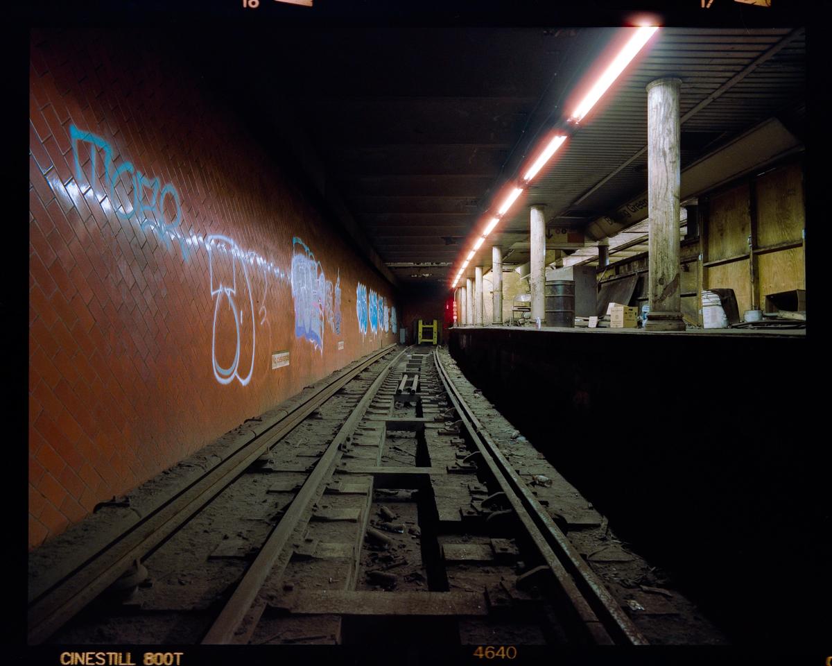 A subway platform and tracks are visible in an abandoned station.