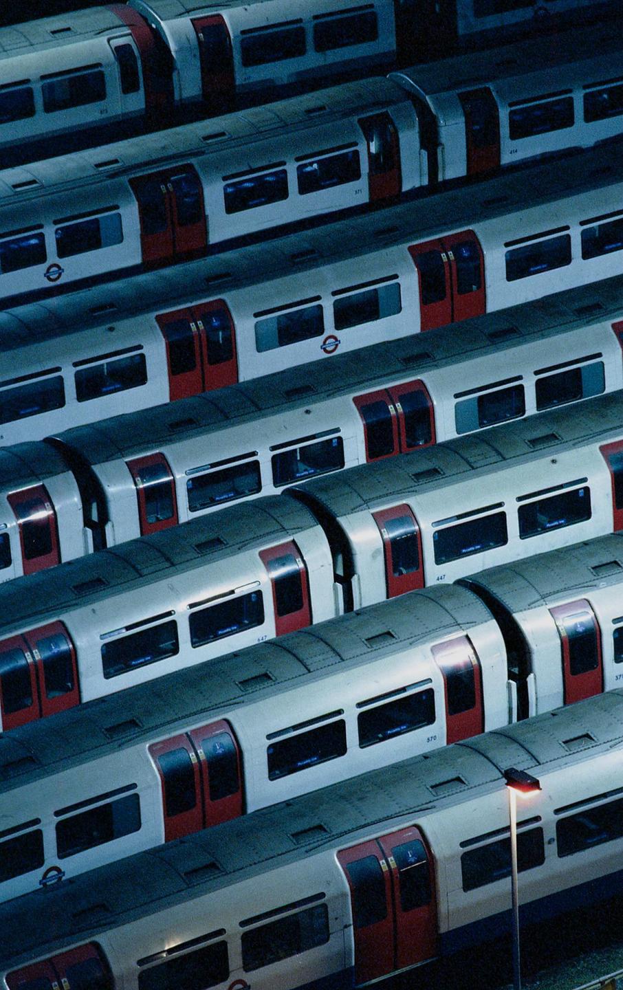 Several subway trains are parked side by side, viewed from above at night.