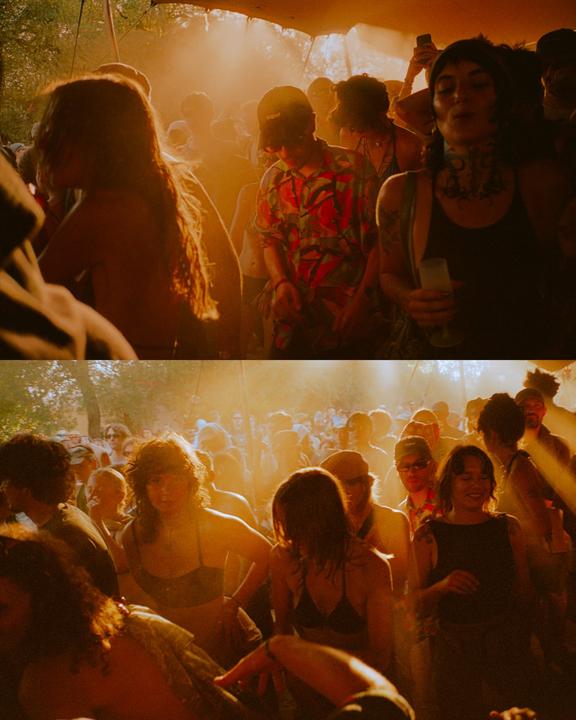 A crowd of people are dancing in a hazy, sunlit outdoor setting.