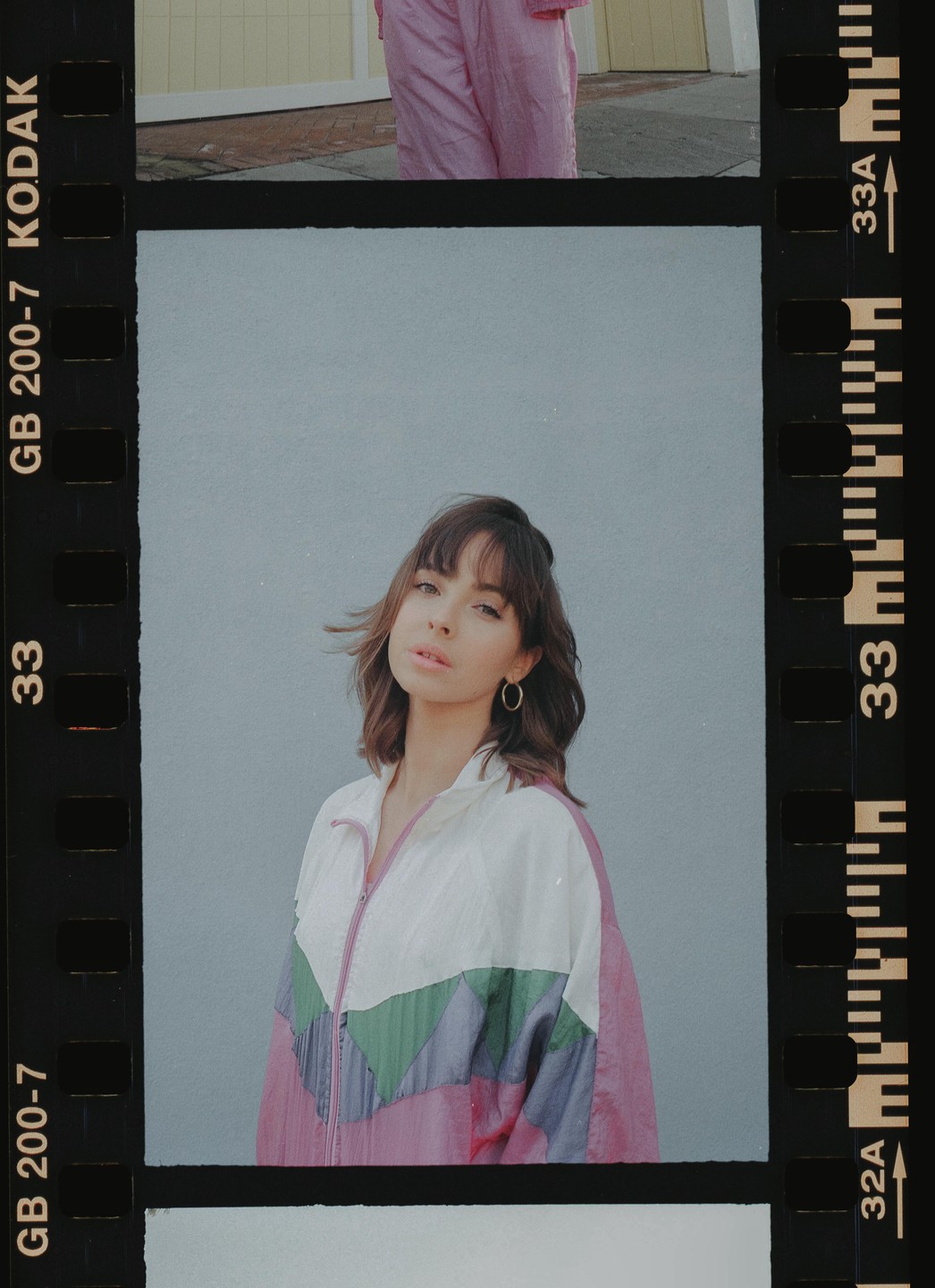 A woman with bangs and a colorful jacket looks directly at the viewer.