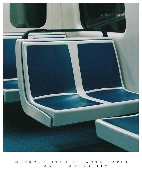 A row of empty blue and white seats is visible inside a train car.