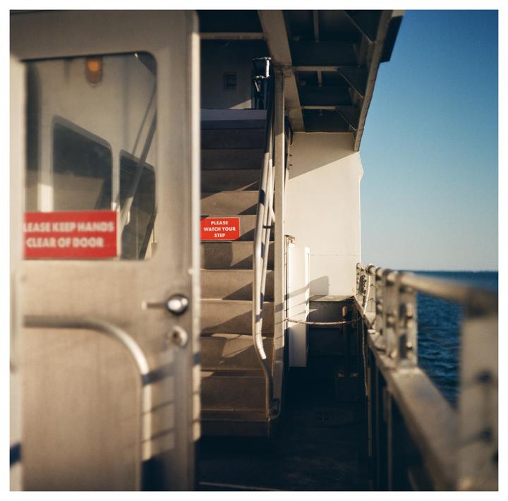 A red warning sign is visible on a staircase next to a door on a boat.