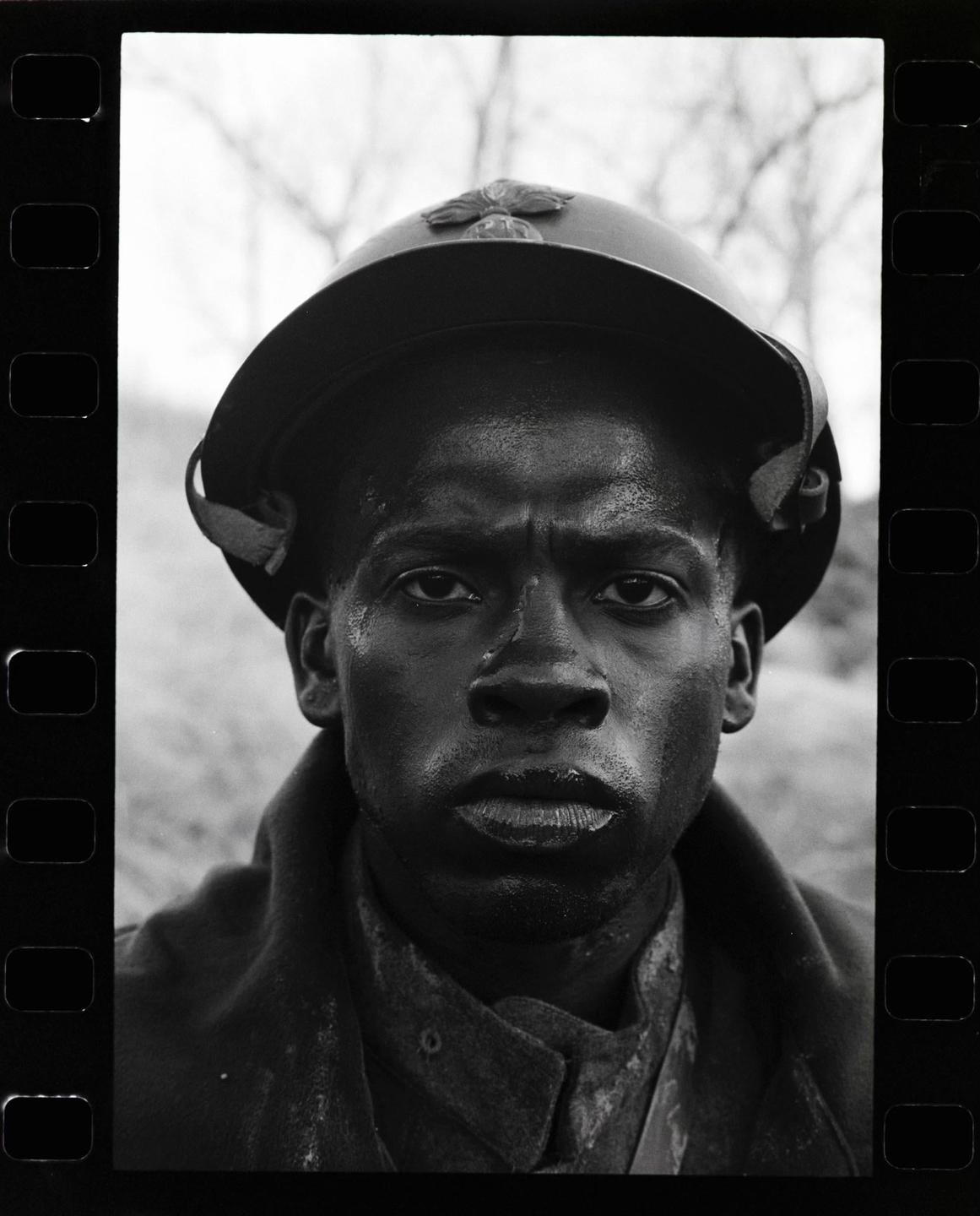 A man wearing a helmet looks directly at the viewer.