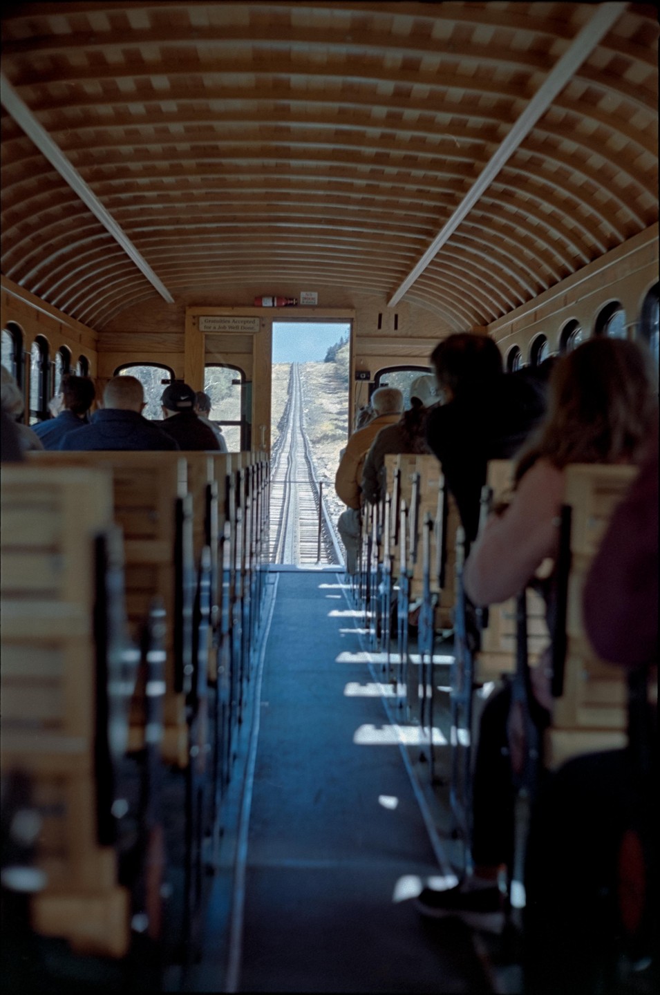 People are riding a train up a steep mountain.