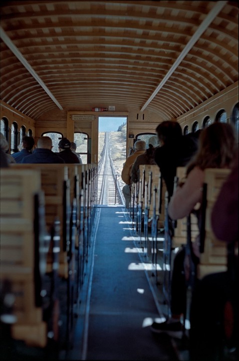 People are riding a train up a steep mountain.