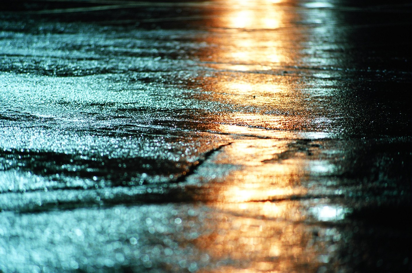 Light reflects off a wet street at night.