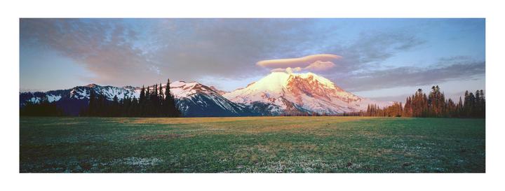 A panoramic landscape shows a snow-capped mountain with a lenticular cloud above it, a forest, and a field of grass under a colorful sky.