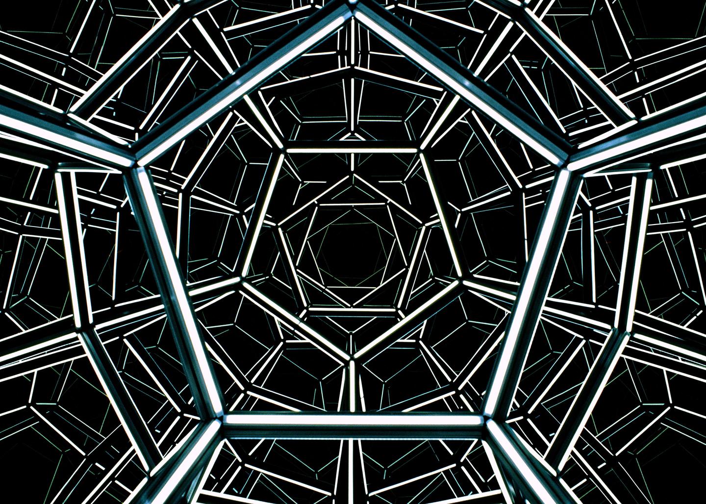 A geometric structure with glowing lines creates an illusion of infinite depth.