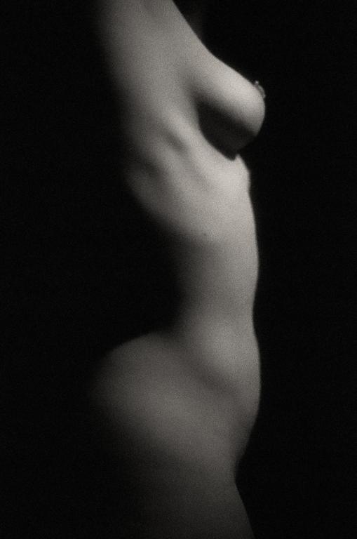 A woman's torso is visible in profile against a dark background.