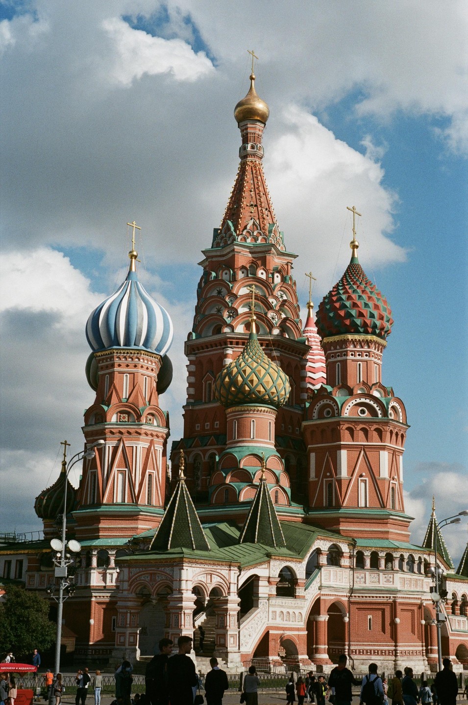 Saint Basil's Cathedral stands tall with its colorful domes and intricate architecture under a partly cloudy sky.