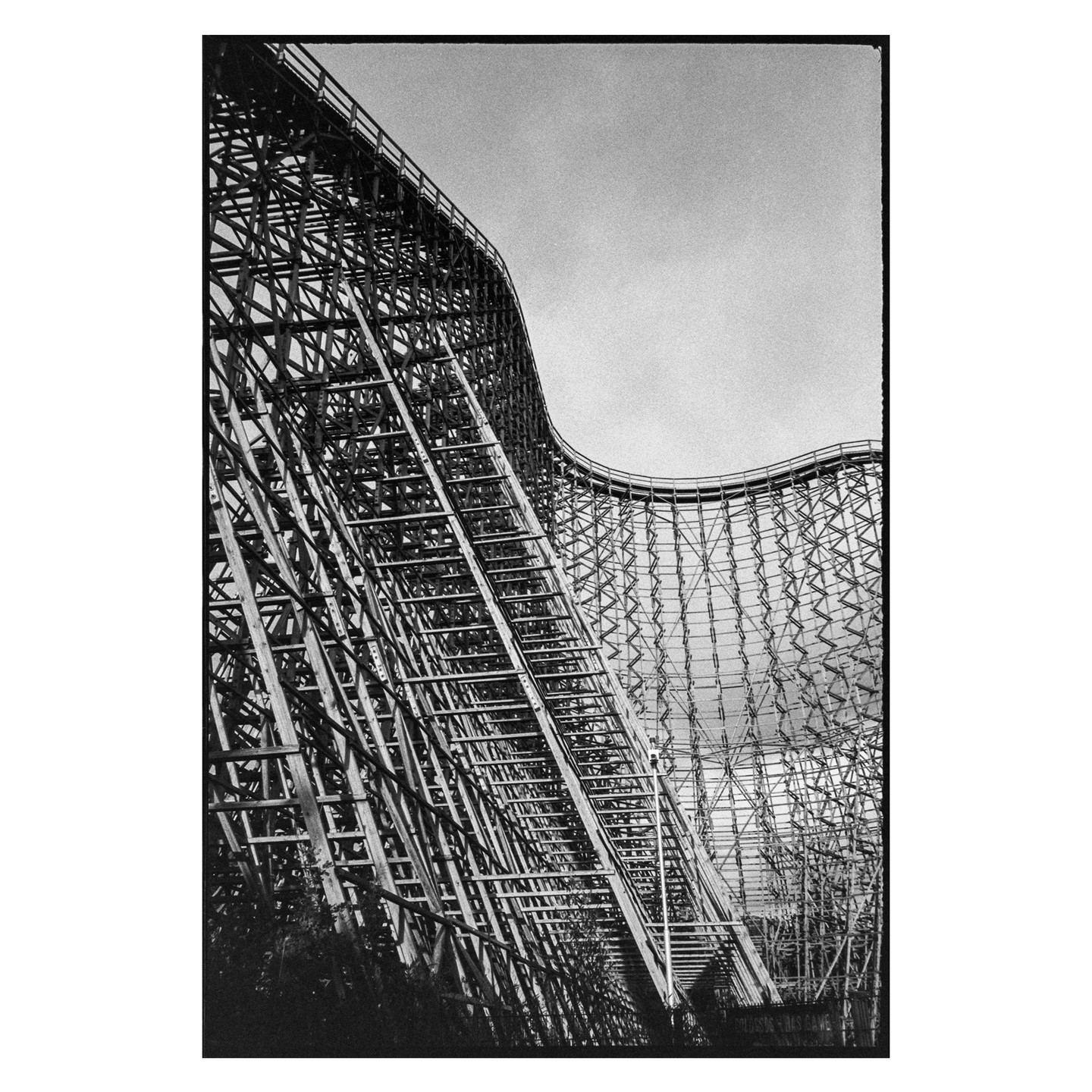 A large wooden roller coaster dominates the frame, with its intricate structure filling the view.