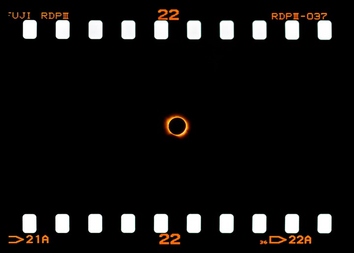 A solar eclipse is visible on a strip of film.