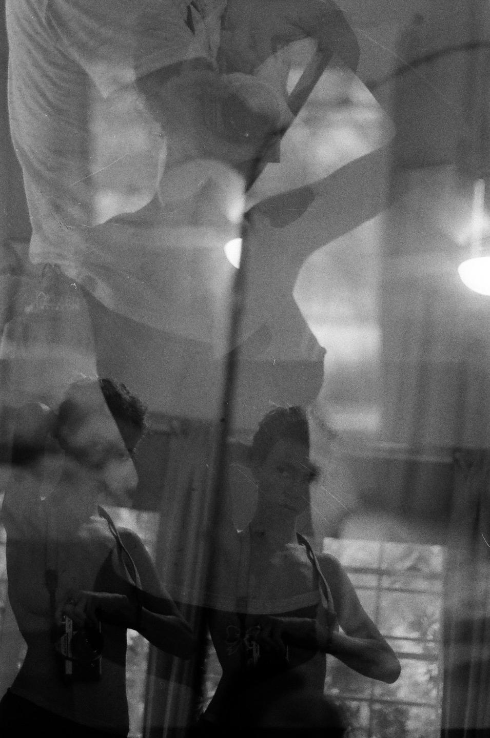 A woman is visible through a triple exposure, with light sources and window frames in the background.