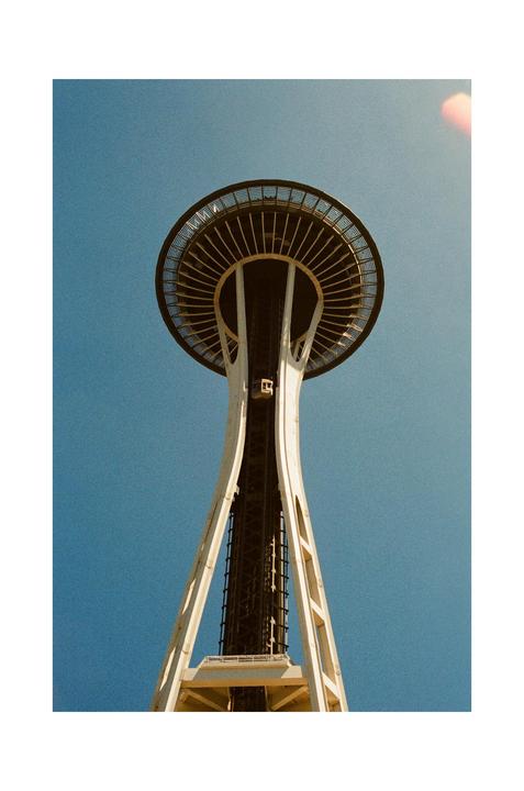 The Space Needle is visible from a low angle against a clear blue sky.