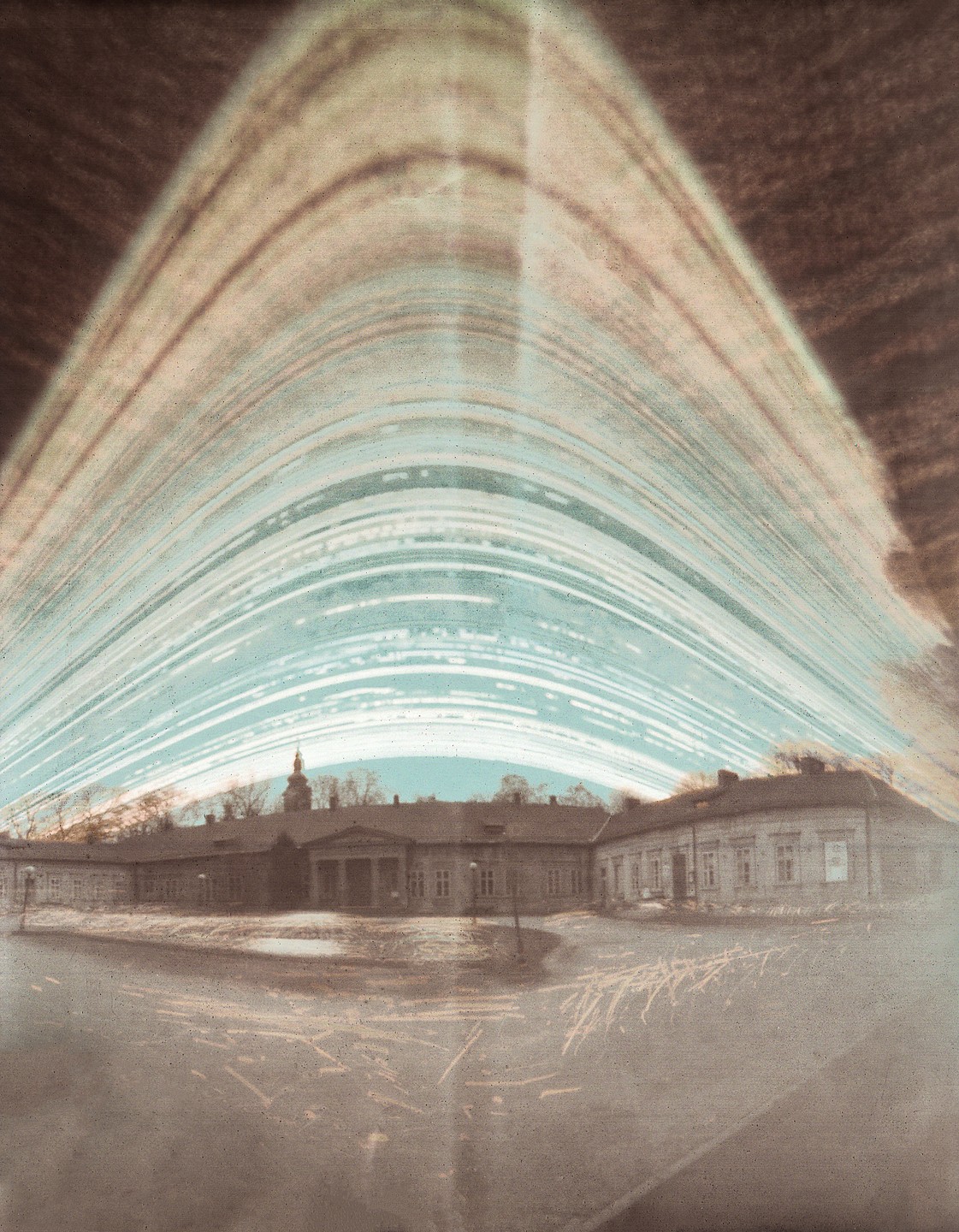 A long exposure photograph shows star trails above a palace with a domed tower.