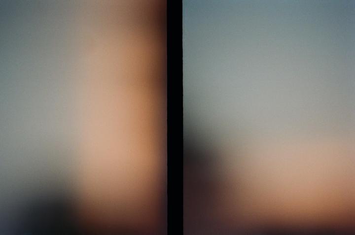 A vertical black bar separates two blurry, gradient fields of color, one with warm tones and the other with cool tones.