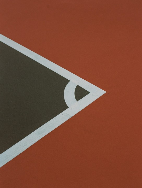 A white line and corner mark are painted on a dark surface next to a reddish-brown surface.