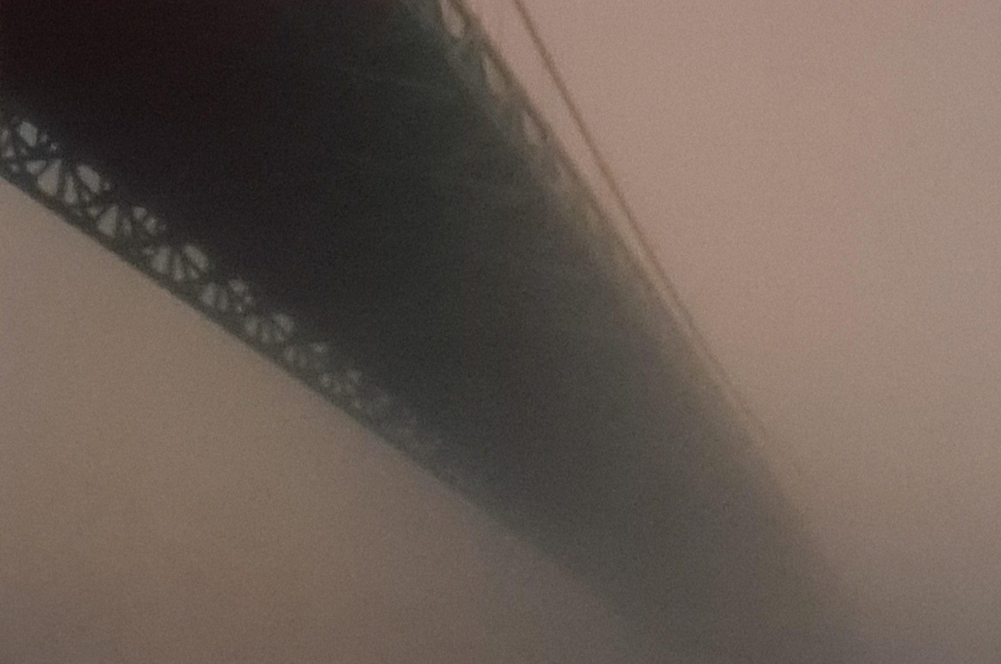 A bridge is partially obscured by thick fog, creating a moody atmosphere.