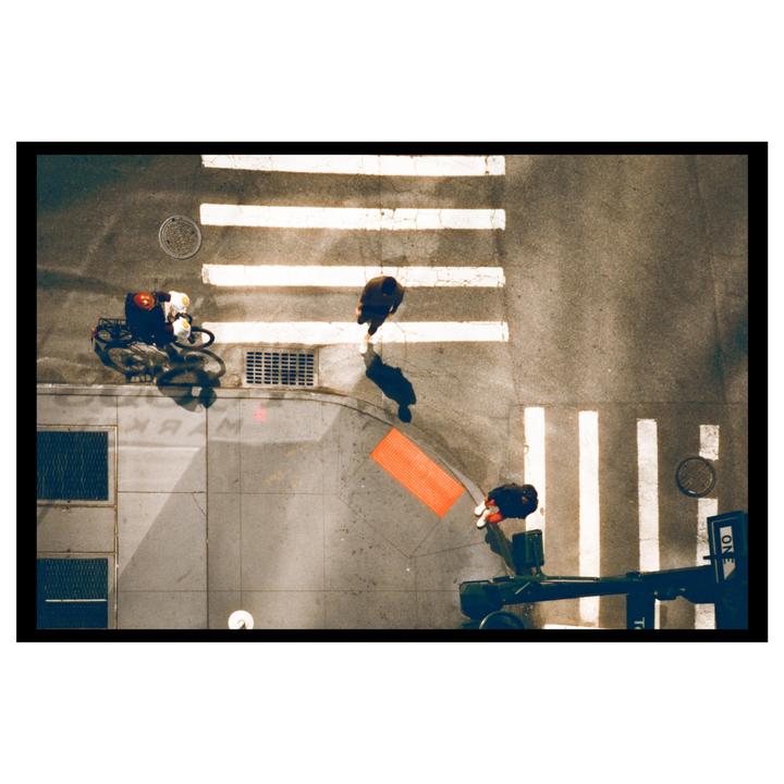 An overhead view shows a cyclist and two pedestrians at a street crossing.