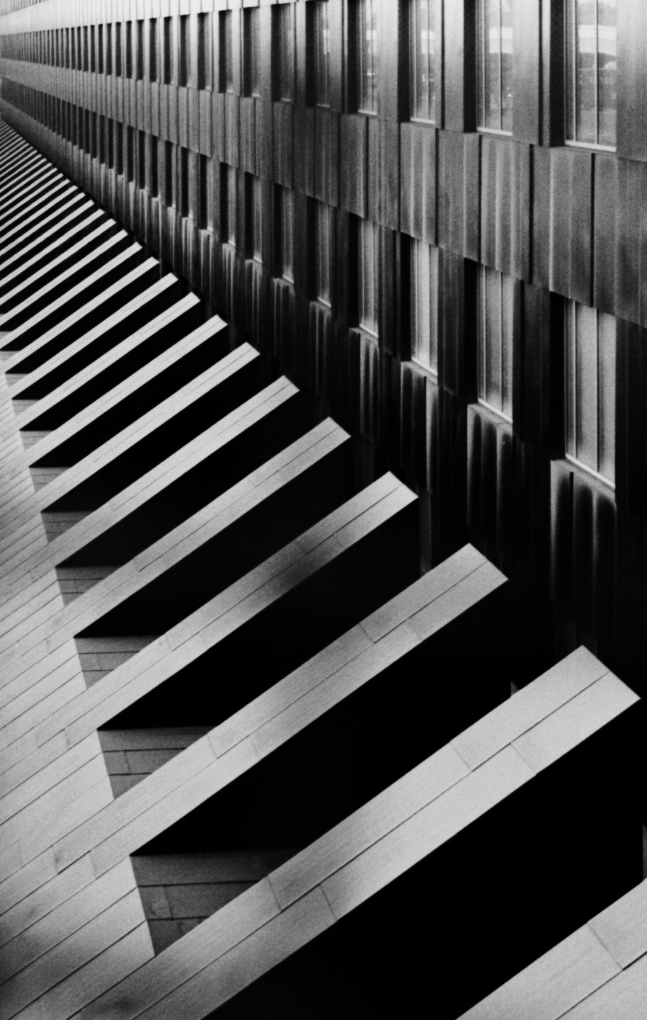 A building facade with a repeating pattern of windows and balconies creates a strong diagonal composition.