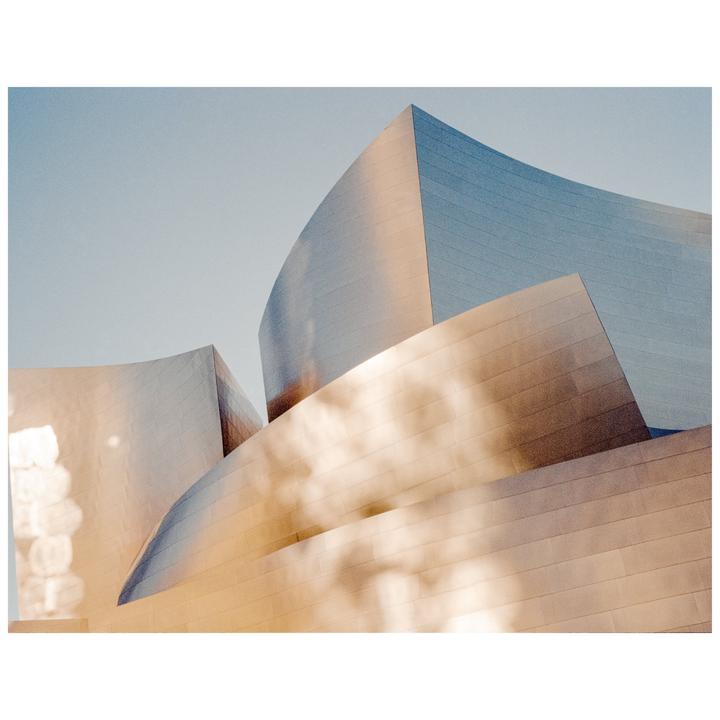 The metallic facade of a modern building reflects the golden hour light.