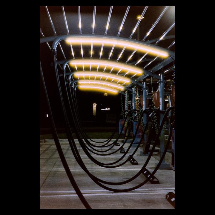 A car wash bay is illuminated by yellow lights at night.