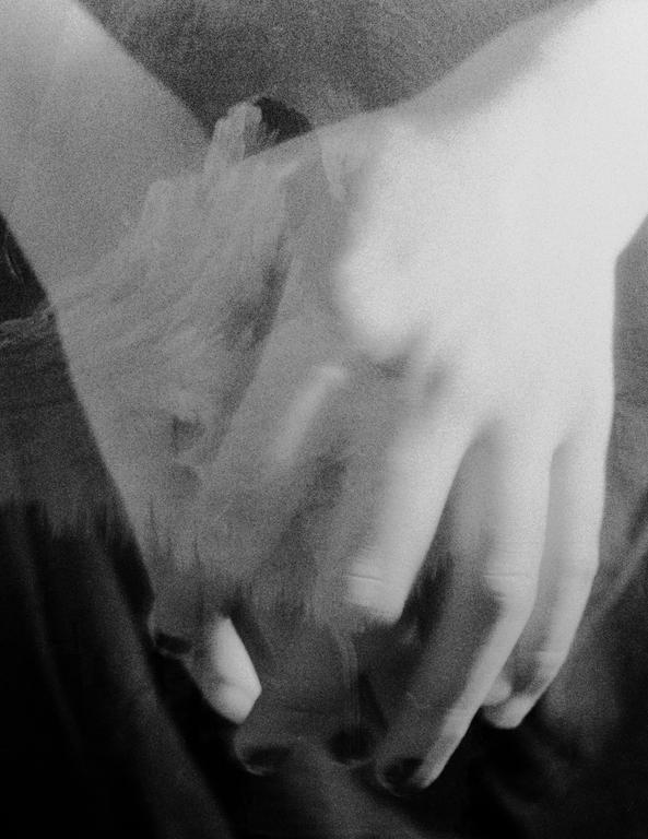Two hands are clasped together with smoke rising between them.