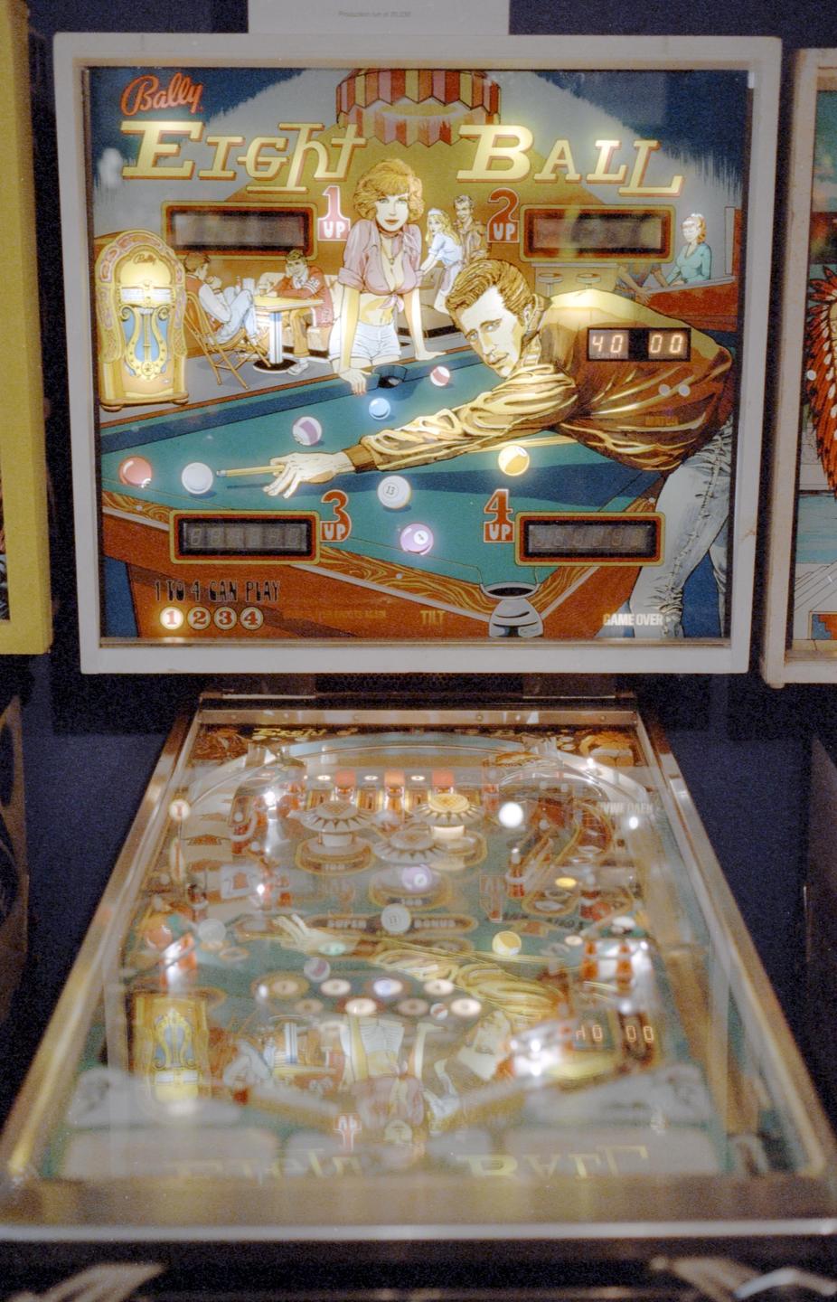 A pinball machine with a backglass depicting people playing pool is shown from a high angle.