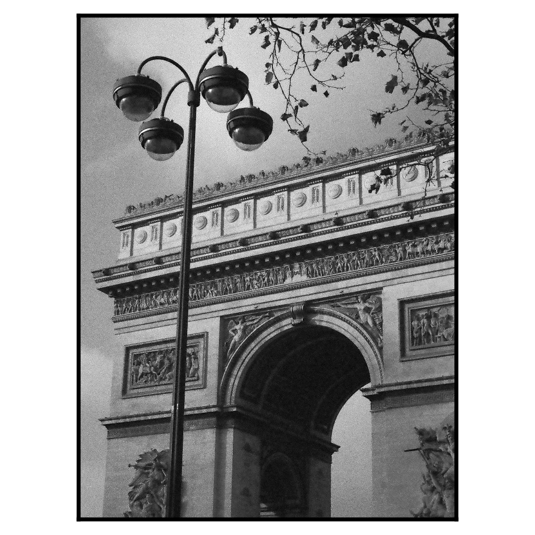 A street lamp stands in front of the Arc de Triomphe in Paris.