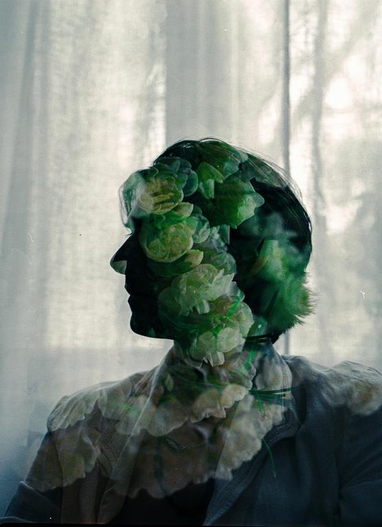 A double exposure shows a man in profile with flowers superimposed over his head and body.
