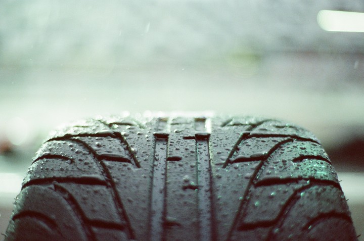 A wet tire with visible tread is shown in a close-up.