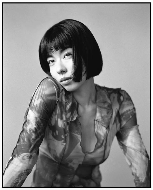 A woman with a bob haircut and bangs looks at the camera.