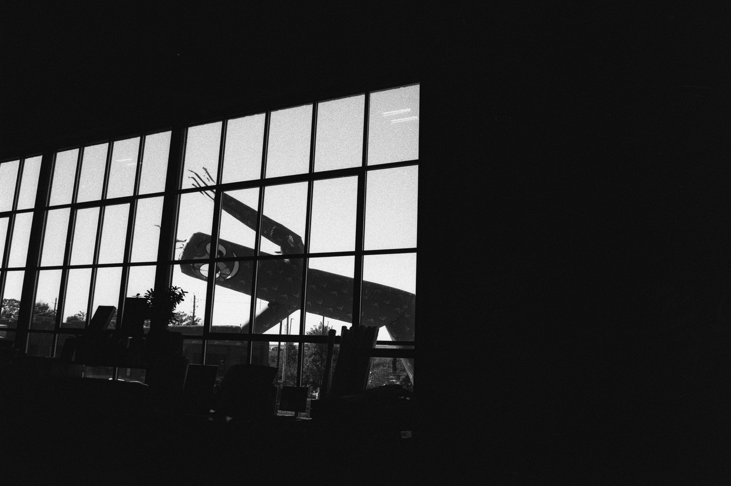 A wacky waving inflatable arm flailing tube man is visible through a large window, with the interior of the building in shadow.