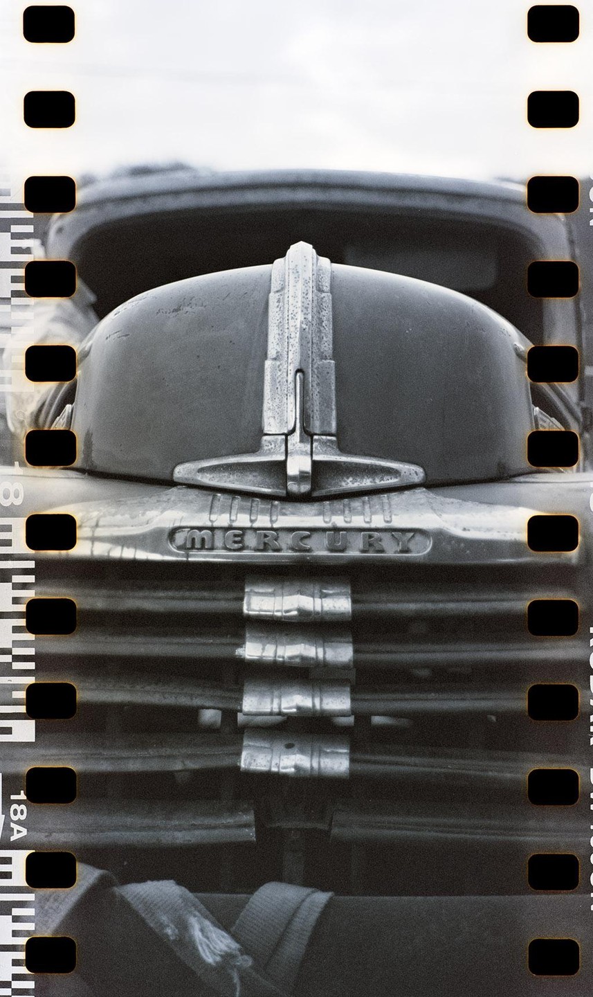 The front of a vintage Mercury vehicle is visible, with its emblem and grille.