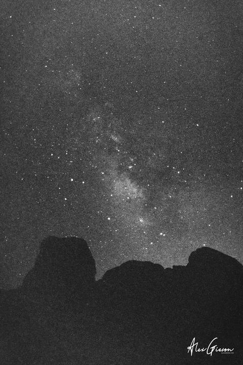 The milky way is visible above a dark mountain range.