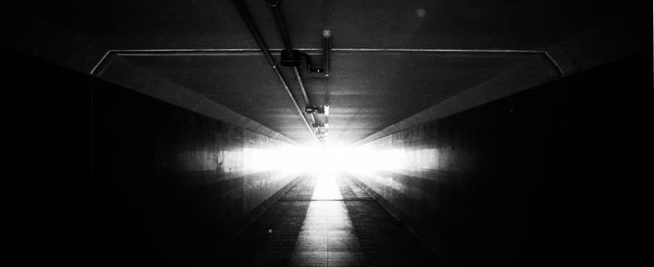 A bright light shines at the end of a long, dark tunnel.