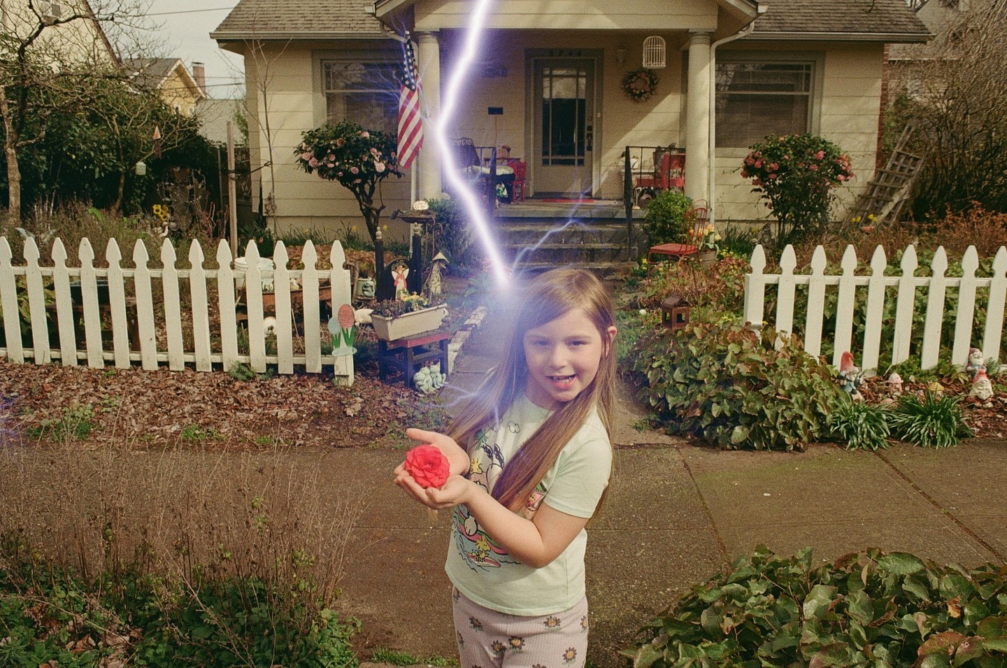 A girl holds a red flower in her hands as a bolt of lightning strikes behind her.
