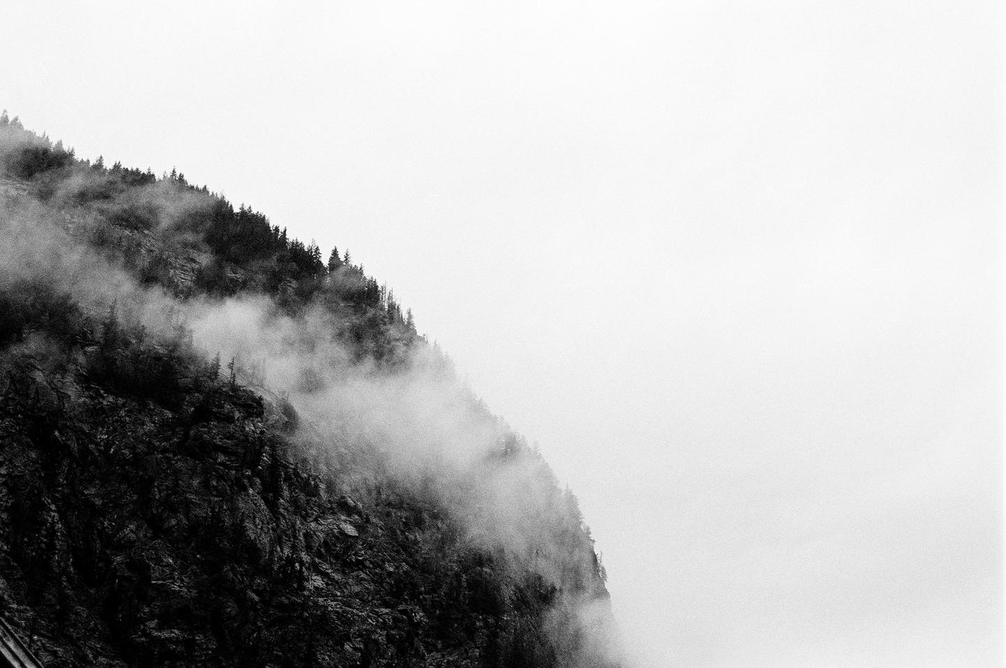 A mountain covered in trees and fog rises from the bottom left corner of the frame.
