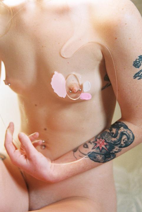 A woman's torso is visible, with a clear plastic sheet covering her chest and a hand resting on her stomach.