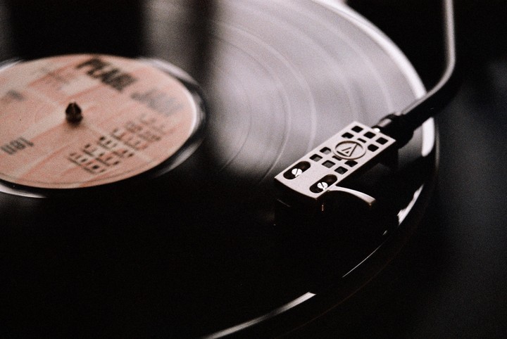 A record player's needle is poised over a spinning vinyl record.